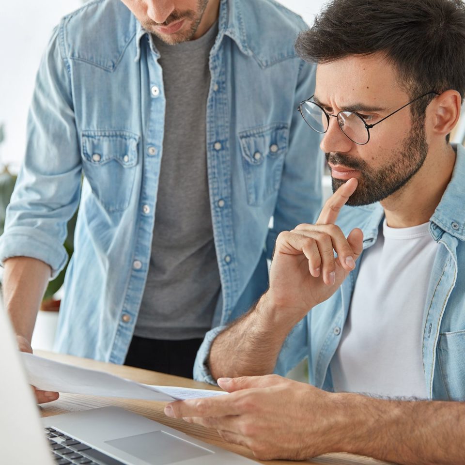 two-successful-stylish-man-financiers-analyze-business-documents-work-new-startup-project